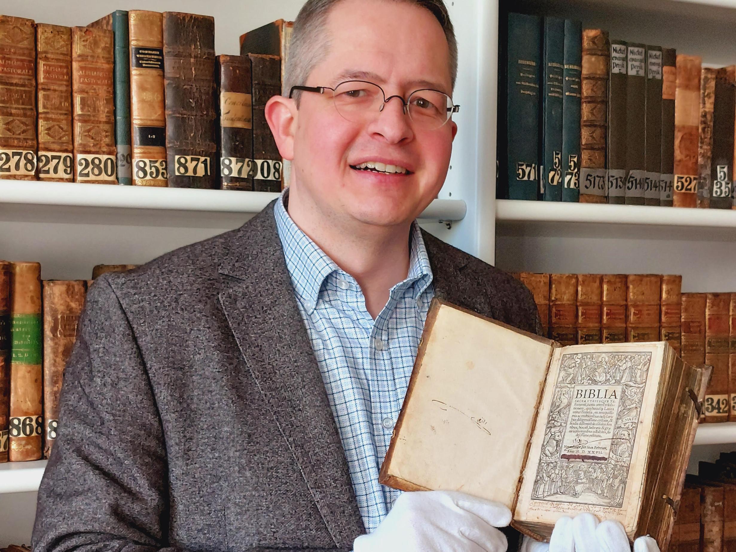 Bibliothekar Dr. Marco Brösch zeigt die Bibel. (Foto: Pia Pastor, St. Nikolaus-Hospital/Cusanusstift, Bernkastel-Kues)