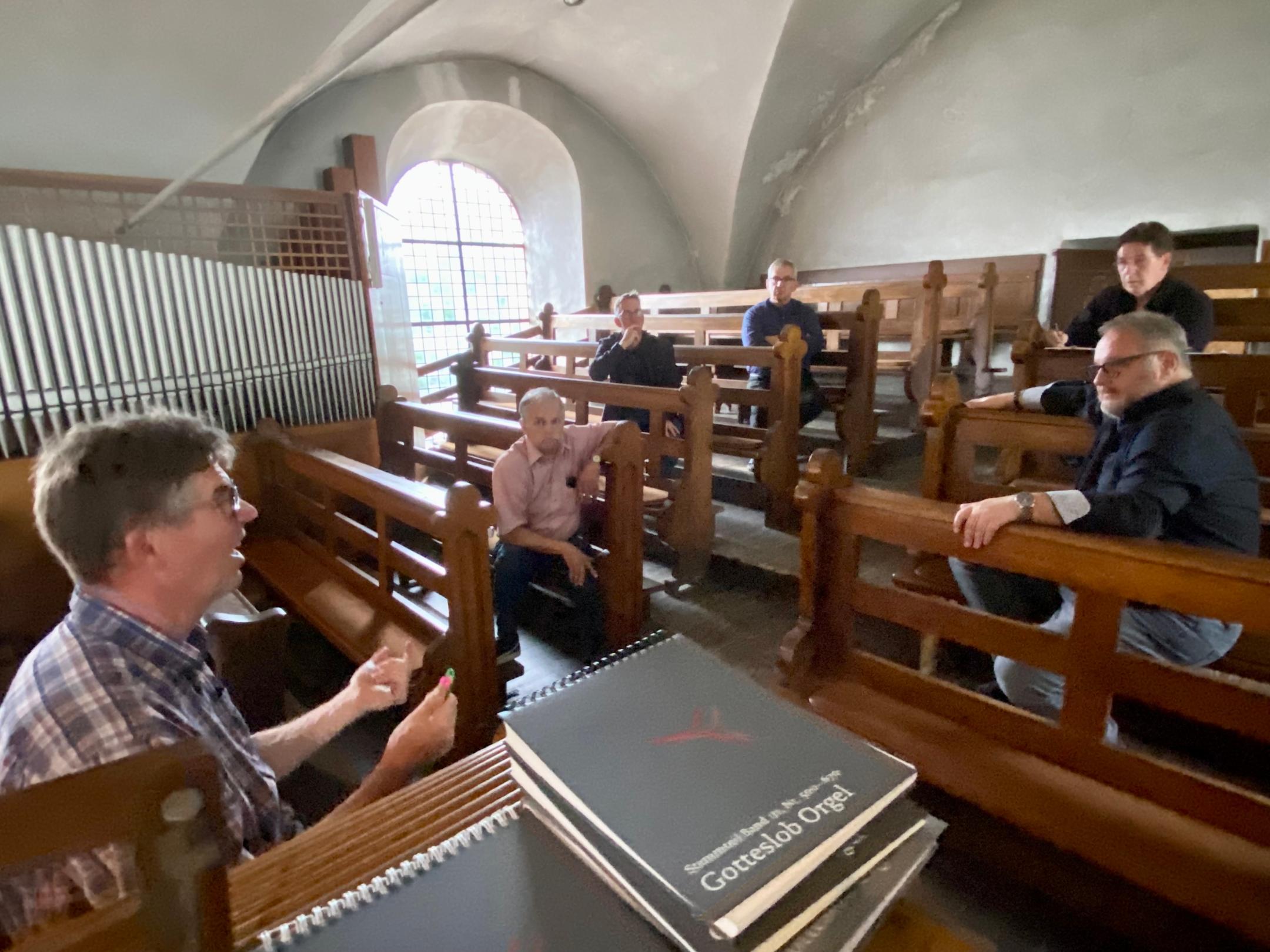 Thomas Esseln aus Kesten (links) vom Verwaltungsrat der Kirchengemeinde St. Matthias im Gespräch mit den Teilnehmern des Ortstermins auf der Empore von St. Georg, über deren Veränderung nachgedacht wird