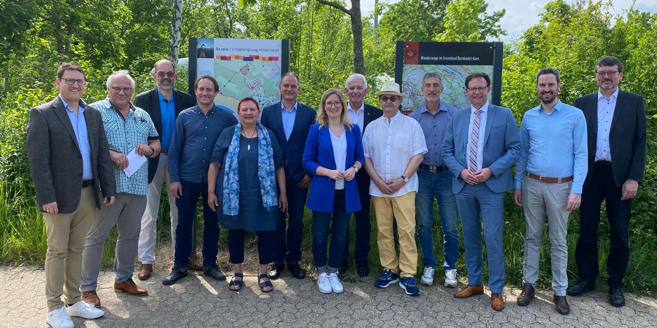Das Planungsteam und weitere Festgäste vor der neuen Tafel des Schöpfungsweges (links)