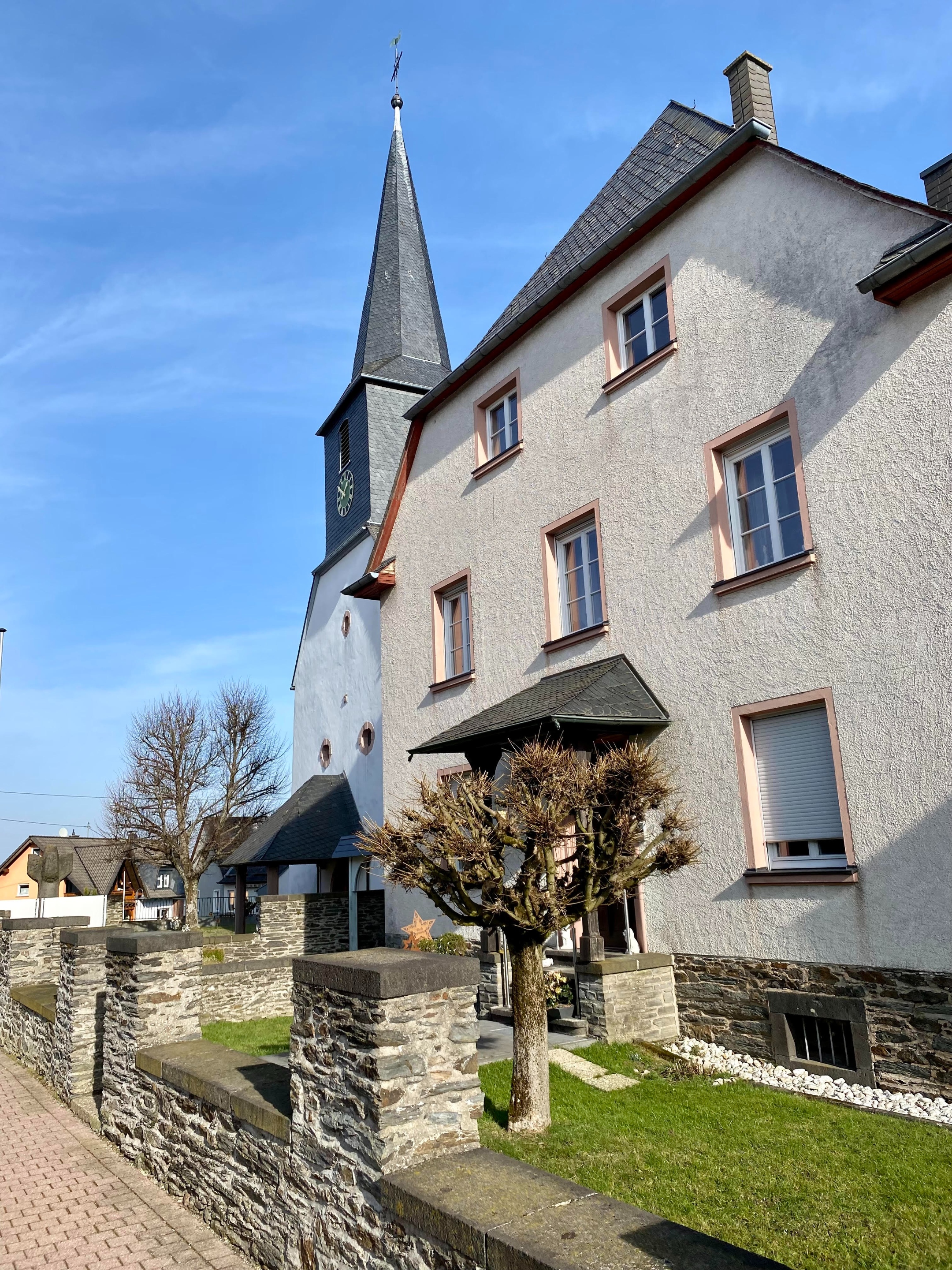 Monzelfeld St. Stephanus 15 - Ansicht von Pfarrhaus und Pfarrkirche im Straßenverlauf